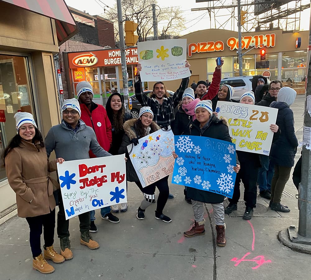 A group of people with signs dressed in winter clothing